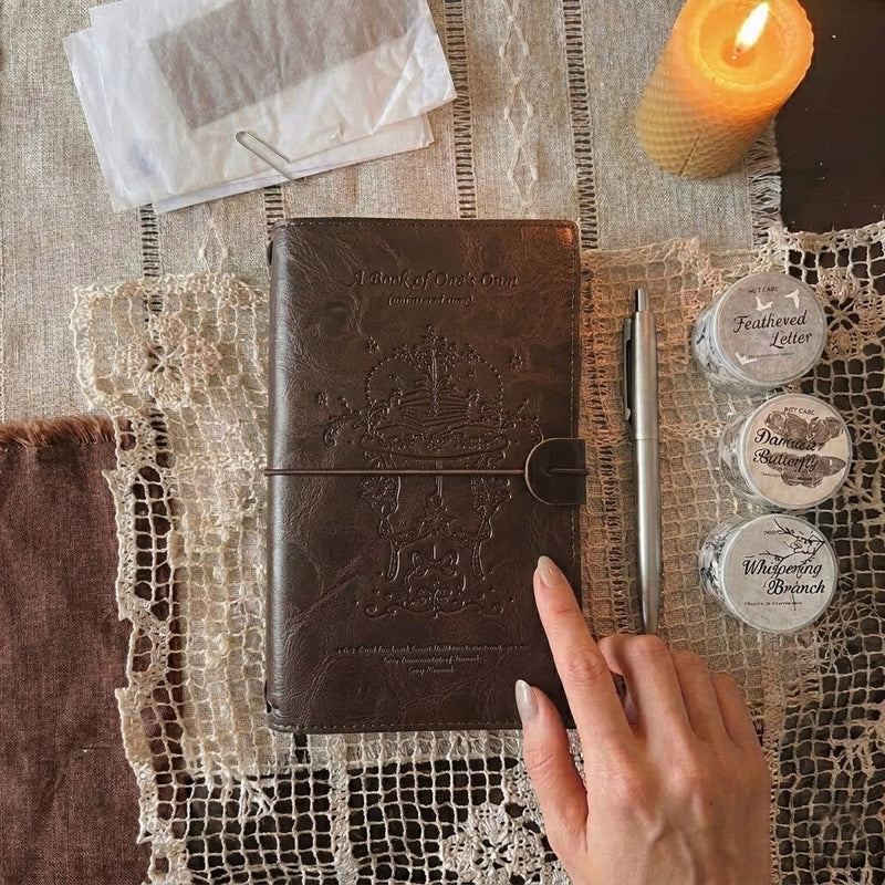 Embossed vintage leather traveler's notebook with washi tape and stationery on a linen flat lay — PaperLooms

