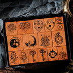 Top-down view of the 16 piece vintage fairy tale stamp collection neatly organized in its display box. Perfect for dark academia scrapbooking and bullet journal layering.