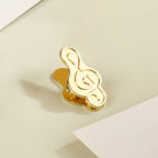 Single antique bronze treble clef metal clip securing vintage journal paper.