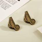 Set of two antique bronze eighth note musical clips for vintage stationery lovers.