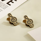 Set of two antique bronze treble clef metal clips for thick junk journal pages.