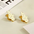 Pair of vintage gold treble clef planner clips displayed together.