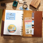 Open leather ring binder journal showing refillable blank pages and rings