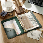 Open leather ring binder journal lying flat with pockets and refill pages