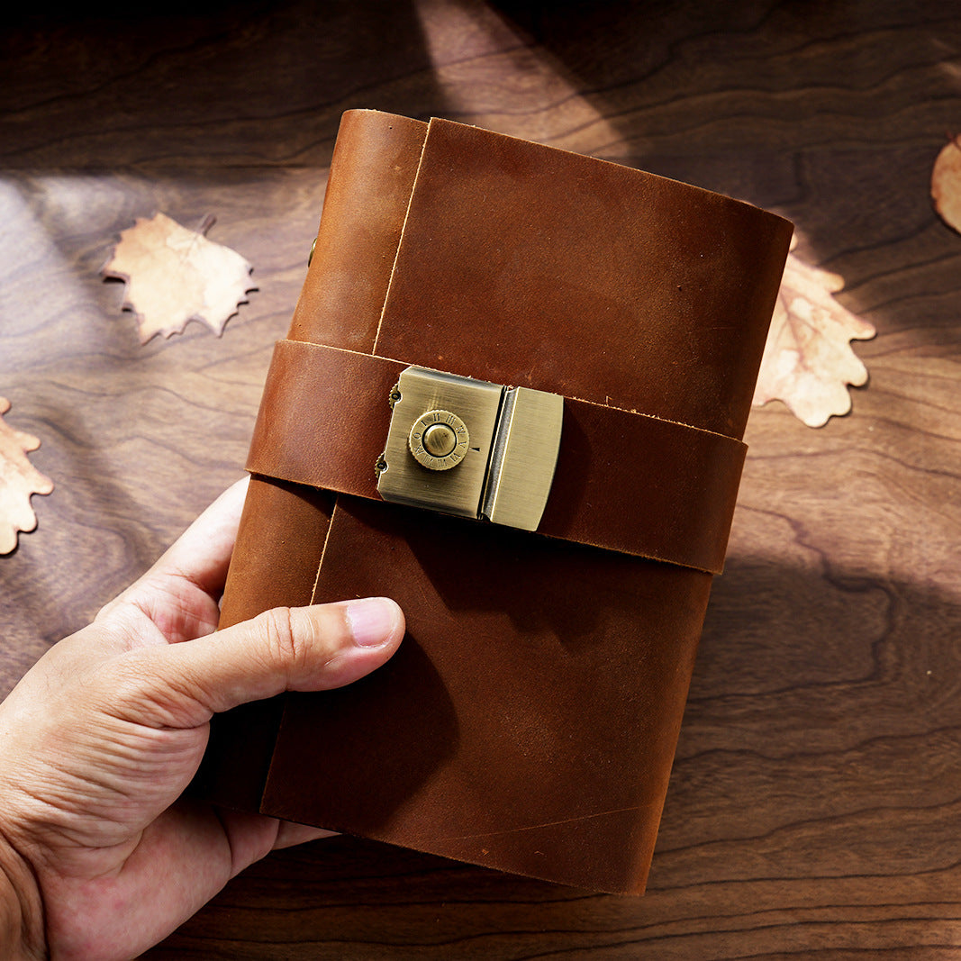 Hand holding small brown leather lock journal A7 showing pocket size