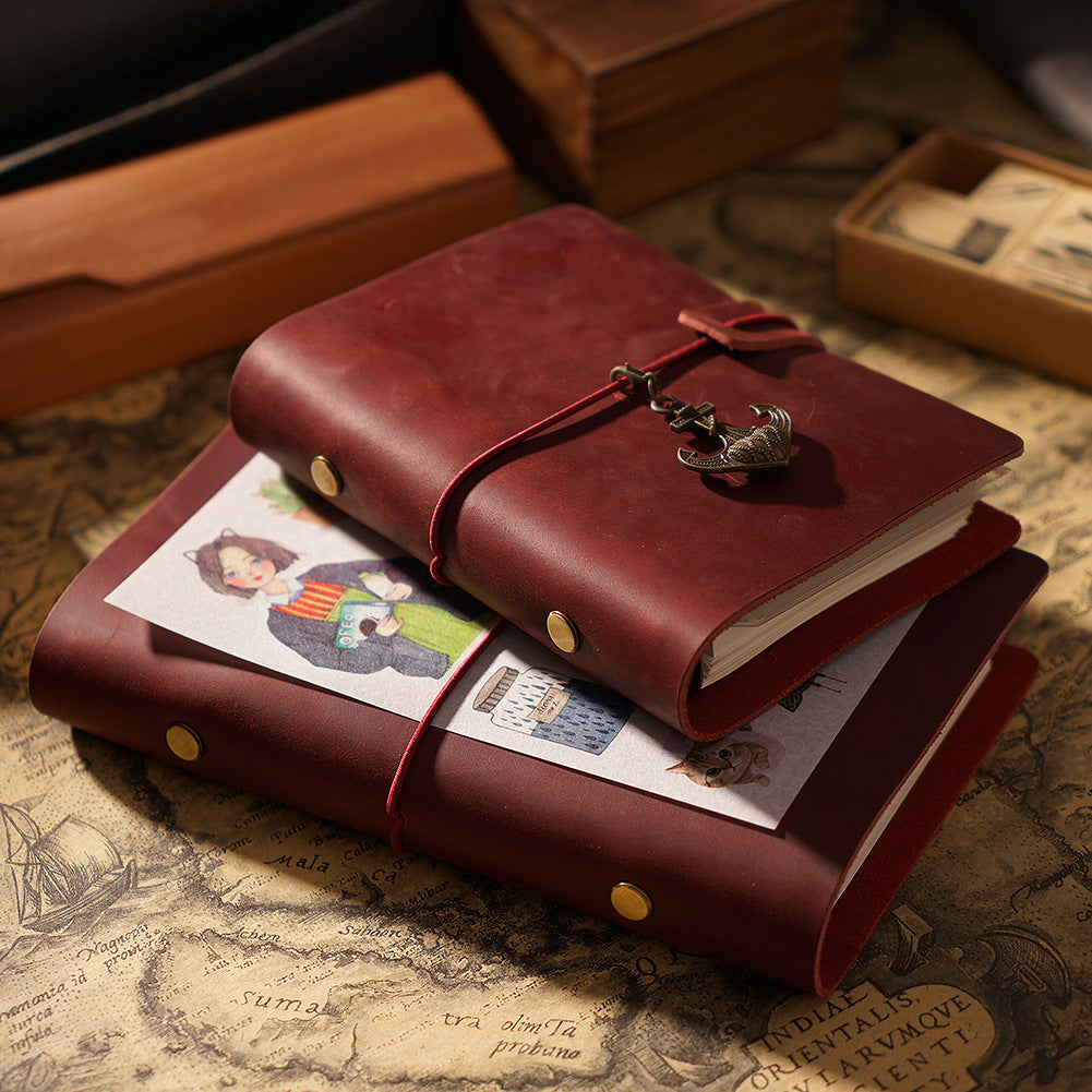 Wine red crazy horse leather ring binder journal stacked on vintage map with brass charm