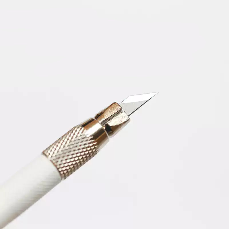 Close-up of anti-slip metal grip and sharp blade of craft knife pen