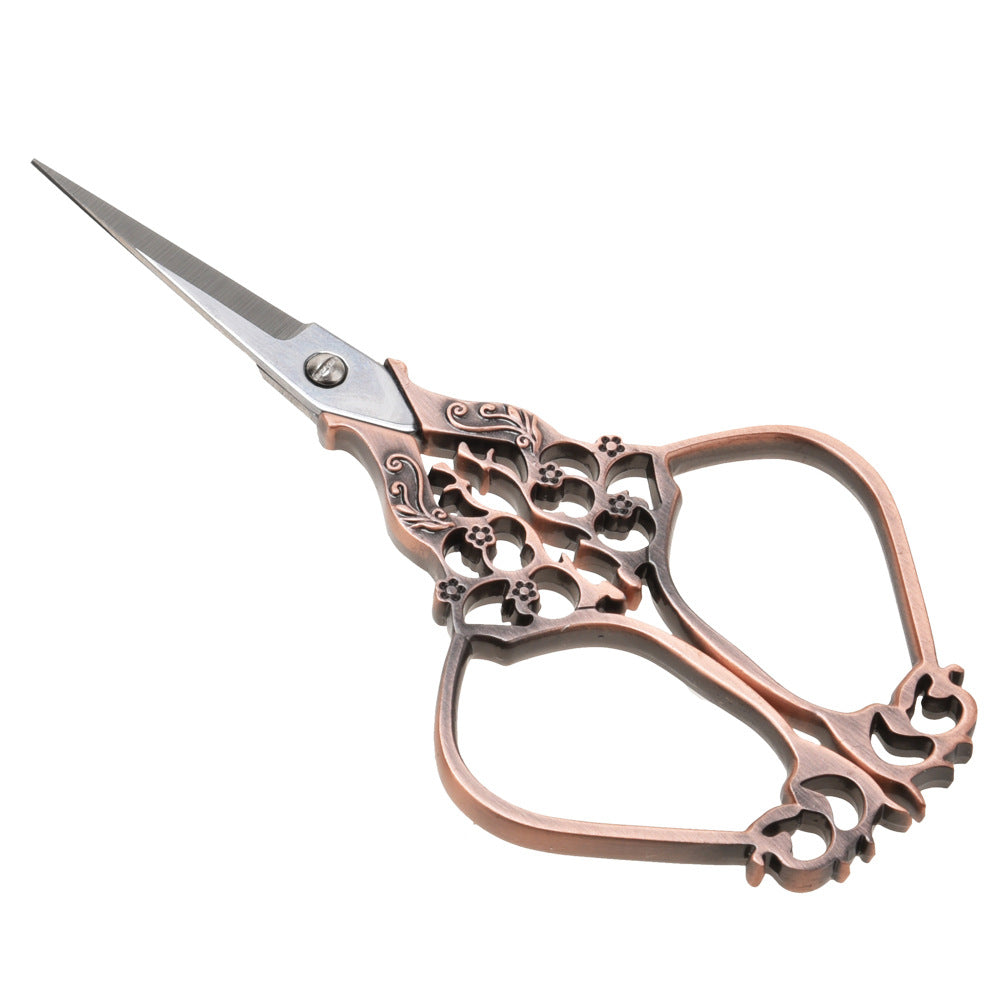 Antique red copper embroidery scissors with ornate filigree handle