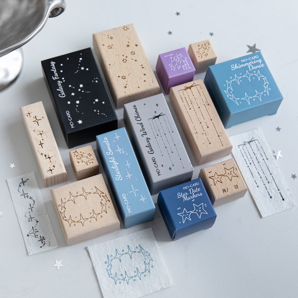 Assorted vintage star beech wood stamps scattered with carved rubber galaxy and constellation impressions, pre-cut celestial stamps for scrapbook night-sky layouts
