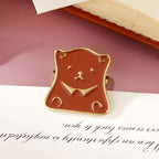 A burnished gold retro bear head metal paper clip resting against a book and letters, designed for heavy-duty planner organization and creative stationery lovers.