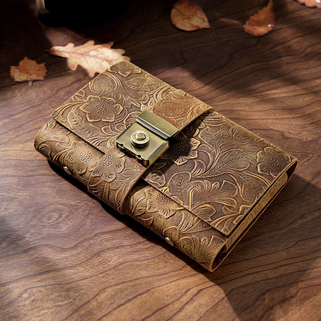 Carved brown leather lock journal A6 closed on wooden desk with autumn leaves
