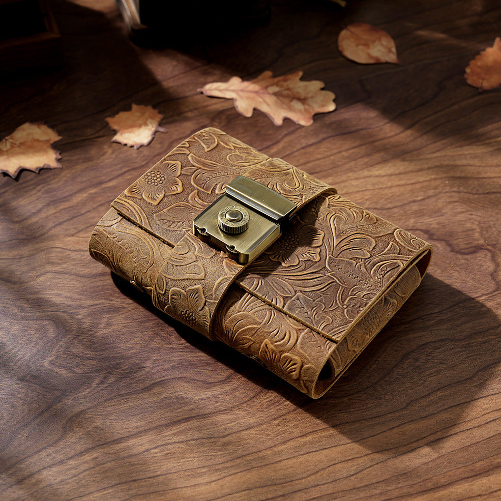 Carved brown leather lock journal A7 closed on wooden desk with leaves