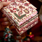 Stack of Christmas glitter sticker books showing the red floral cover design