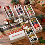 Five boxes of Christmas washi tape rolls unrolled on wooden table with pine cones
