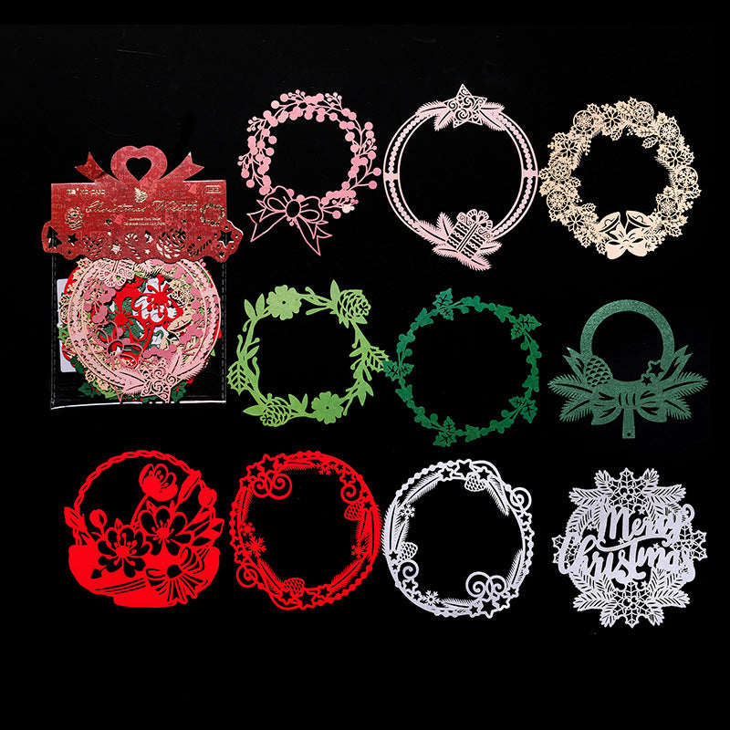 Red green and white laser cut Christmas wreath paper pieces on black