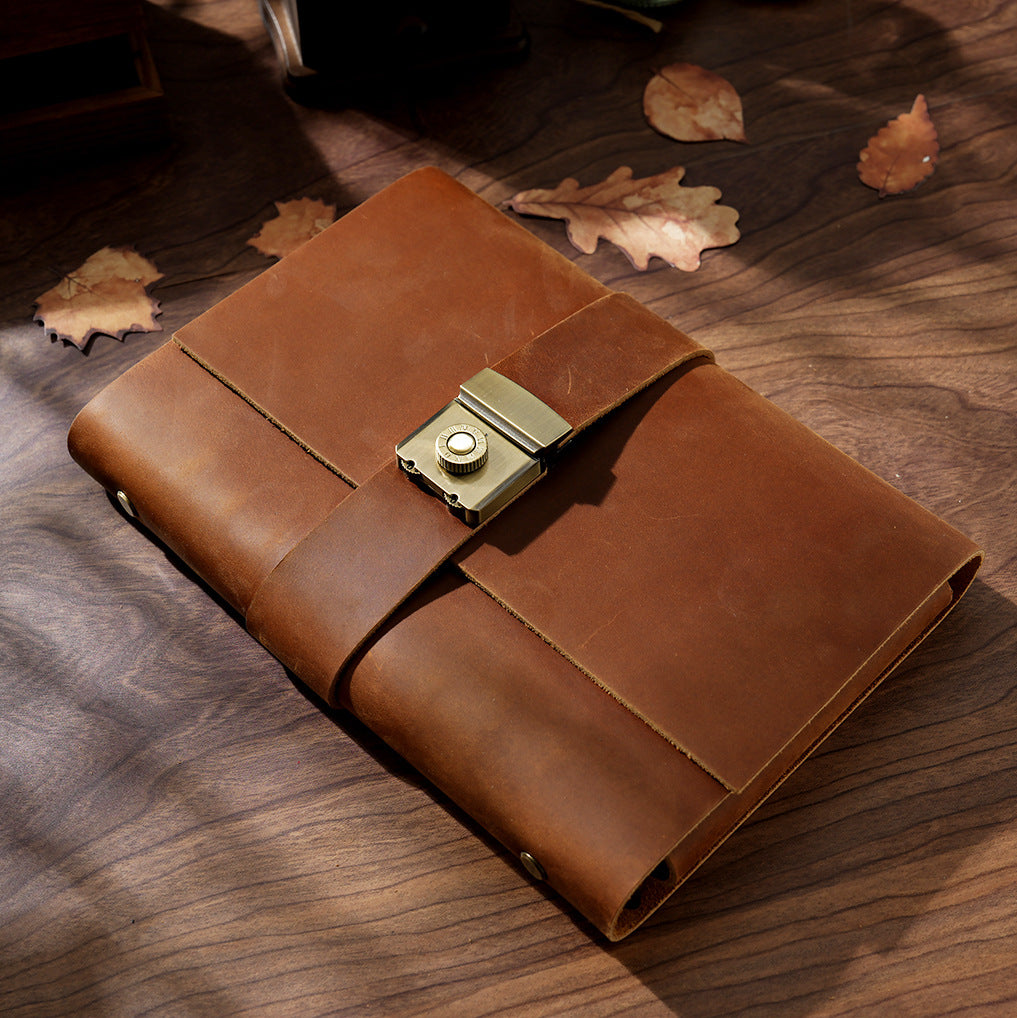 Variant image of the Classic Rustic Brown genuine crazy horse leather lock journal. Features a smooth, rich brown top-grain leather cover with a heavy-duty vintage metal combination lock, elegantly styled on a wooden desk with scattered autumn leaves.