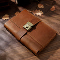 Variant image of the Classic Rustic Brown genuine crazy horse leather lock journal. Features a smooth, rich brown top-grain leather cover with a heavy-duty vintage metal combination lock, elegantly styled on a wooden desk with scattered autumn leaves.