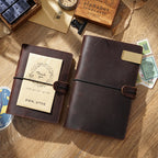 Two coffee brown leather ring binder journals stacked on wooden desk