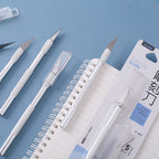 Craft knife set with spare blades and safety storage case on notebook