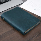 Dark green B5 leather ring binder journal on desk beside laptop