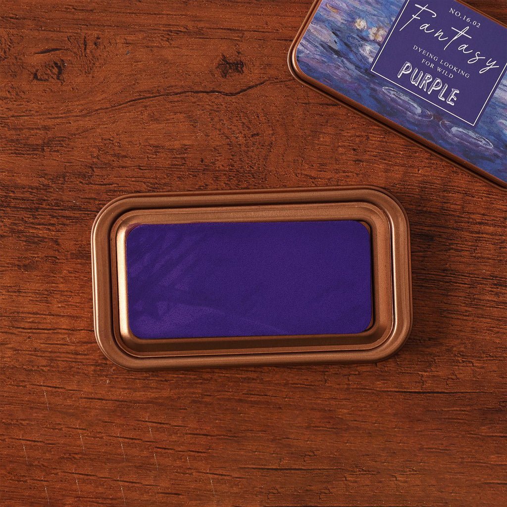 Vintage iron box ink pad in Dream Purple open on wood, purple lid beside
