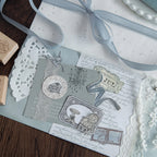 Wood stamps with ribbon and blue-toned stamped ephemera