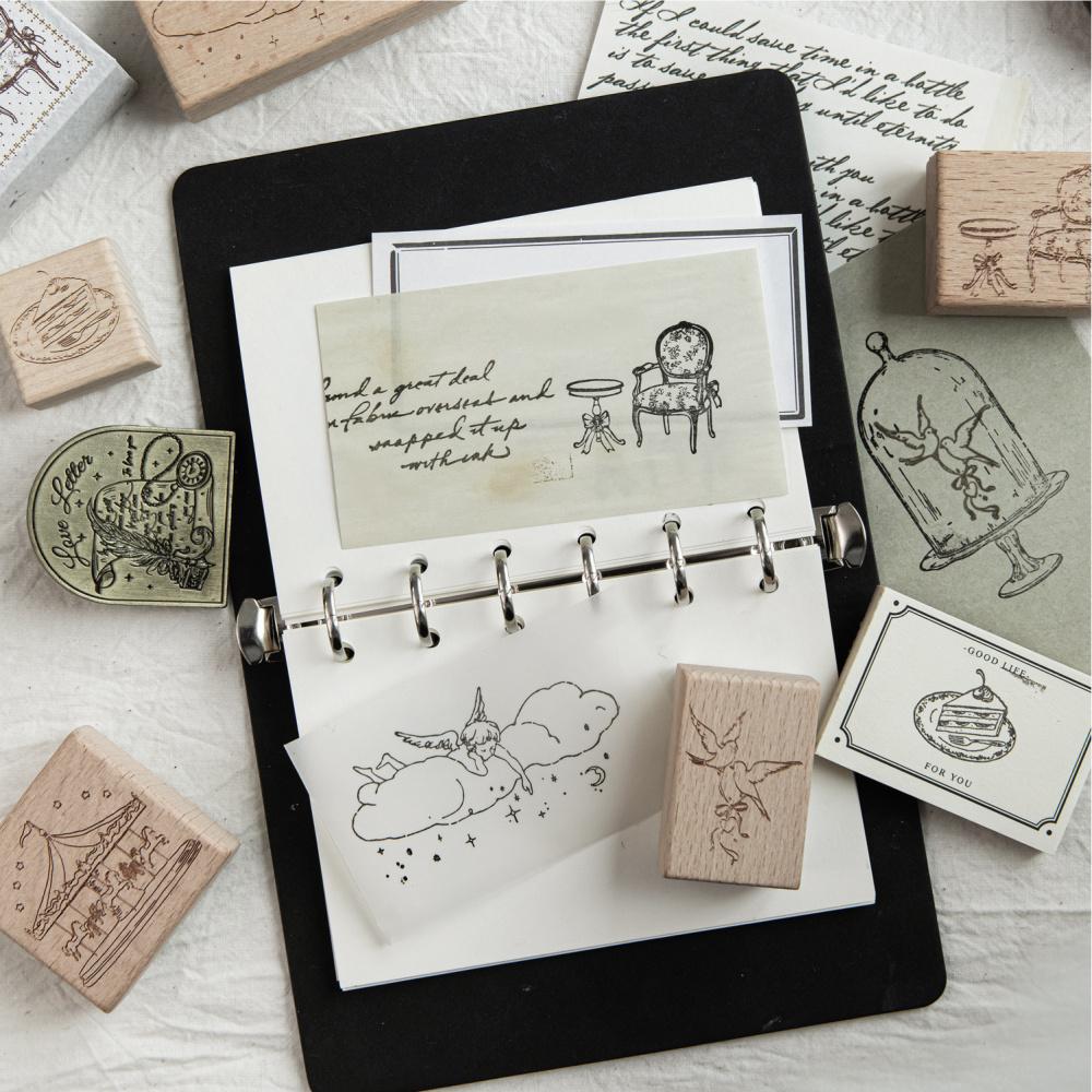 Fairy-tale motifs stamped into a black journal beside beech wood stamps