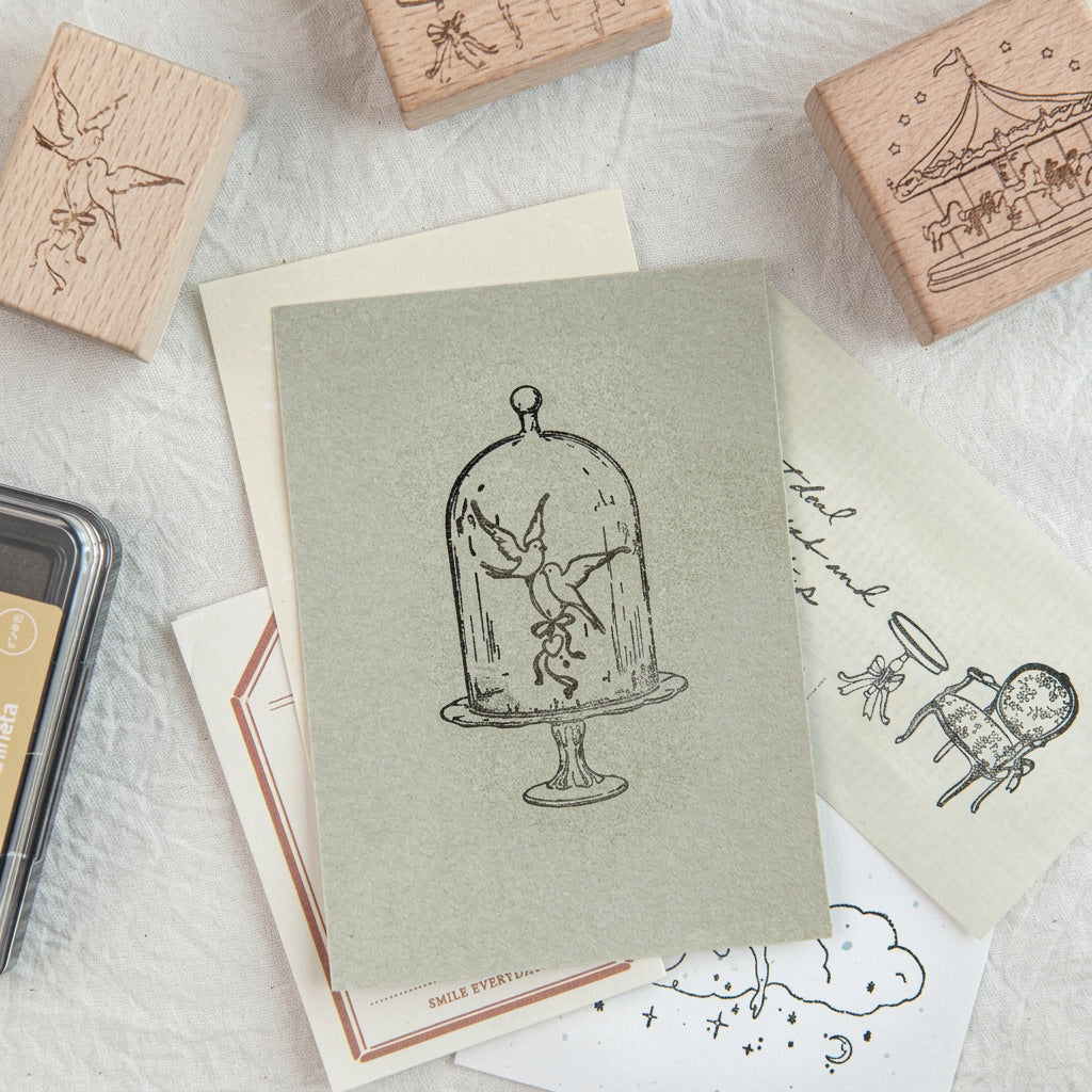 Birdcage and dome stamp impressions on green paper with wood stamps