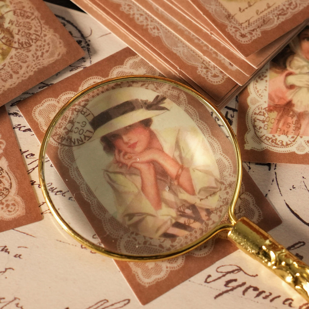 Closeup of victorian girl portrait sticker under magnifying glass lace frame details