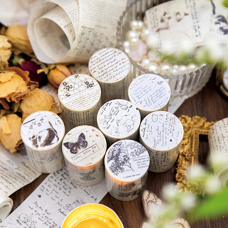 Eight vintage washi tape rolls top view with handwritten labels botanical and manuscript designs on aged paper
