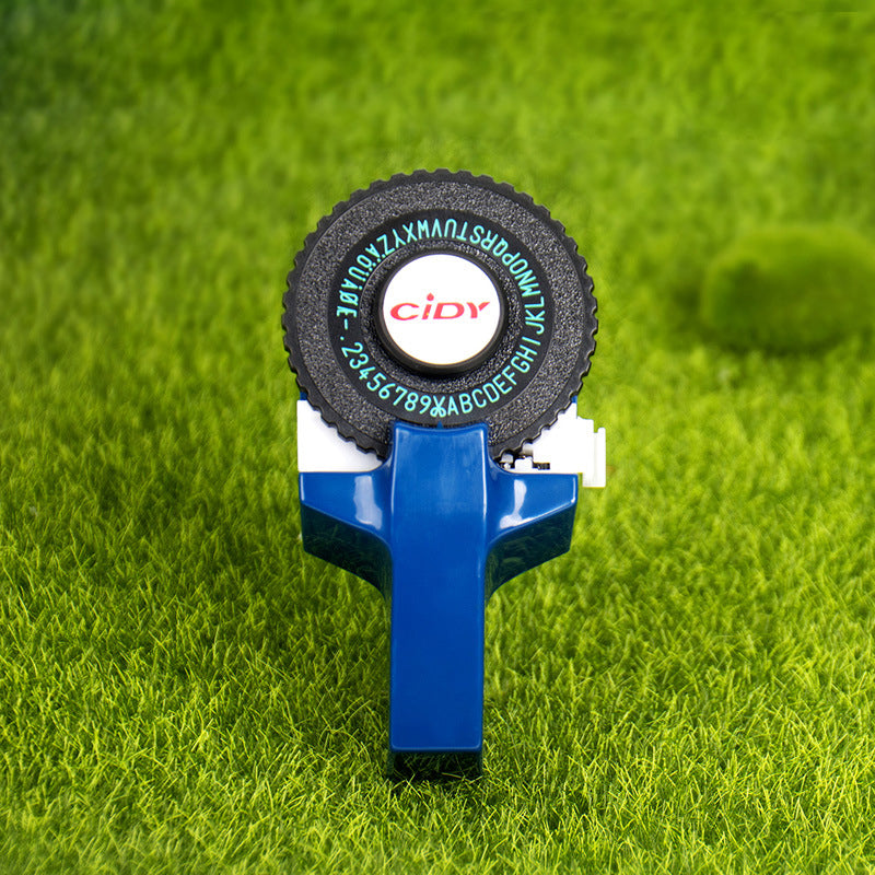 Dark blue embossing label maker on grass background