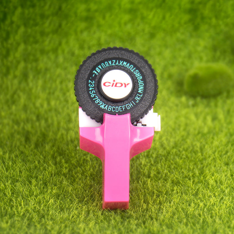 Pink embossing label maker on grass background