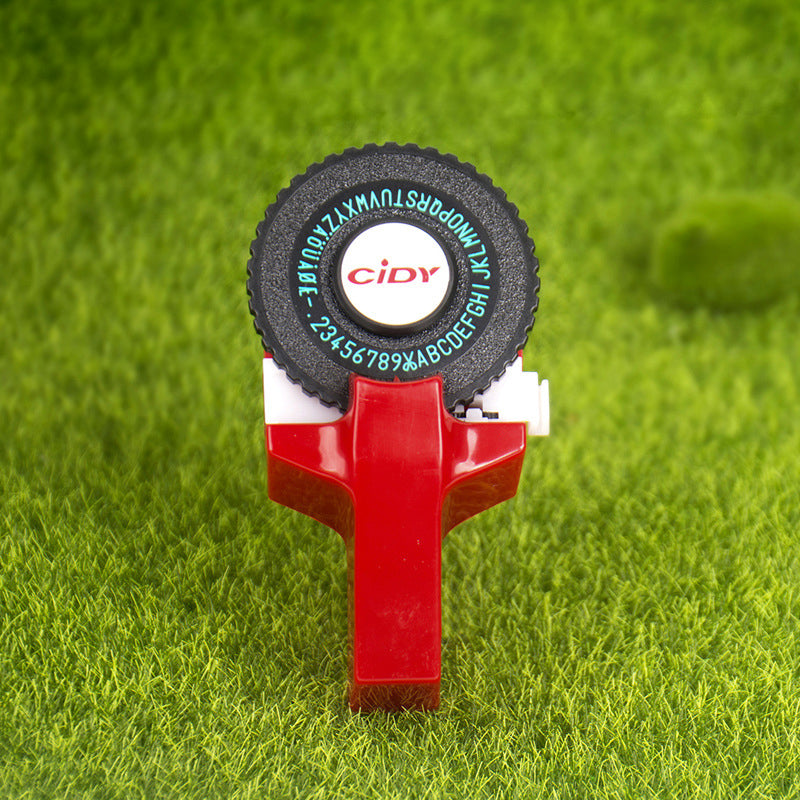 Red embossing label maker on grass background