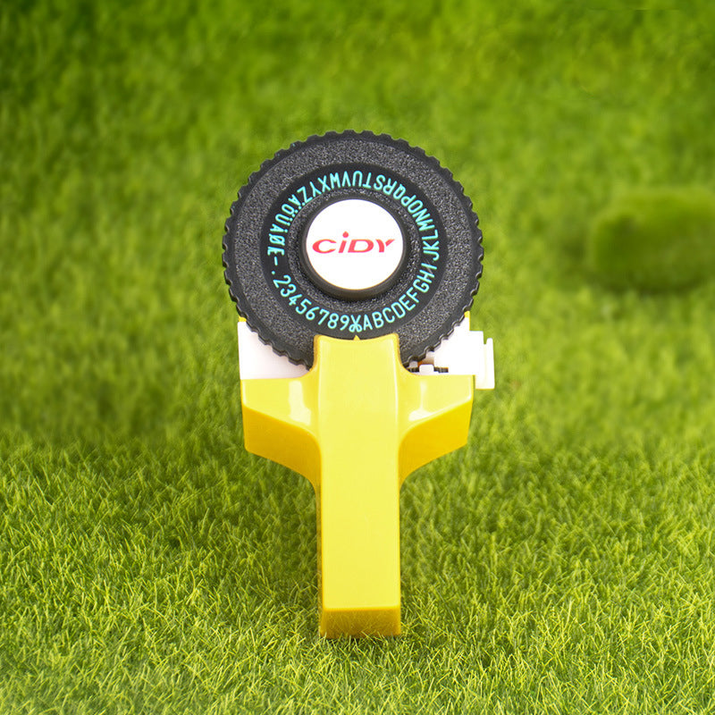 Yellow embossing label maker on grass background