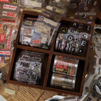 Four vintage ephemera PET tapes organized in wooden compartment box with ticket alphabet and newspaper clipping designs
