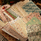 Assorted floral scrapbook paper sheets fanned on a wooden surface, featuring botanical prints, pressed flowers, and vintage garden patterns.