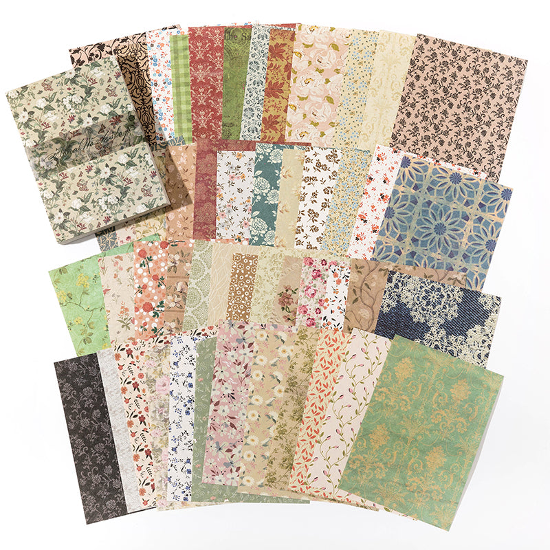 Fanned decorative paper sheets with small repeating florals, damask patterns, and vintage wallpaper prints in soft pastel tones.