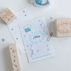 Vintage star beech wood rubber stamps in use with blue constellation impressions on white paper, star face date stamp and star trail border stamps, pre-cut celestial carved rubber stamps for journal decoration