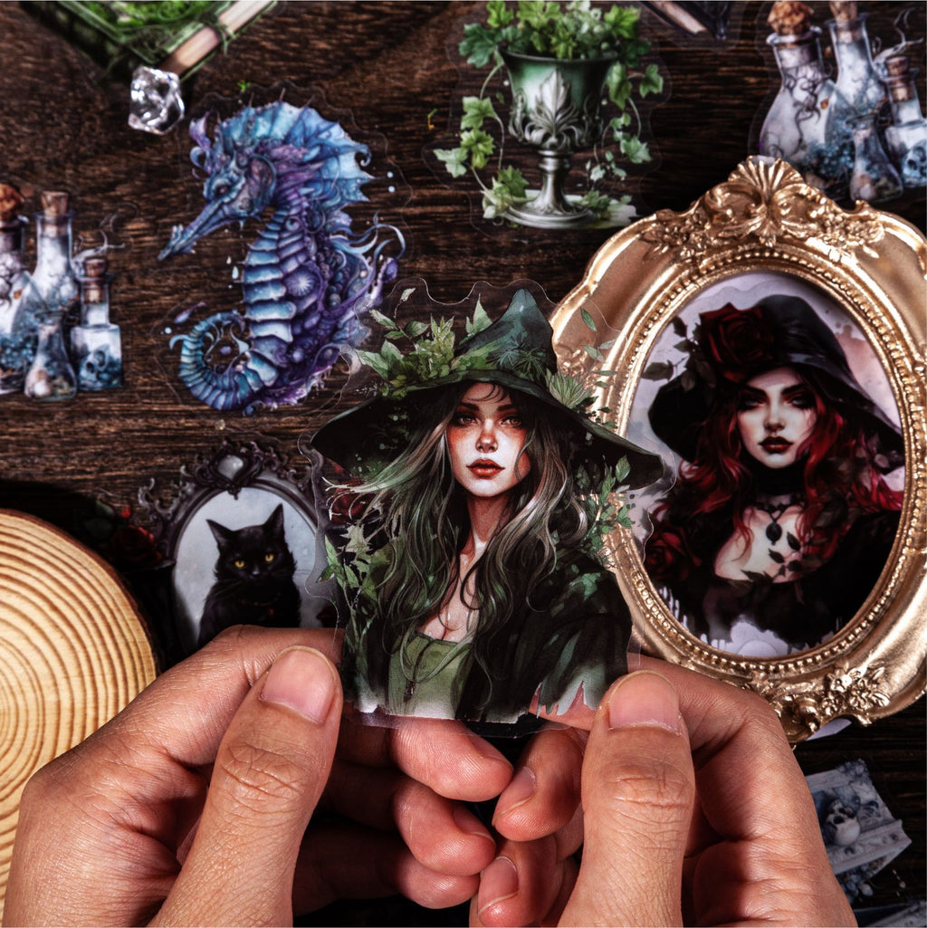 Hands holding framed gothic witch stickers with ornate mirror decor