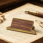 Walnut wood journal clip with antique bronze frame resting on open book pages