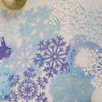 Blue and white laser cut snowflake lace paper on light blue background