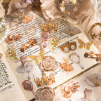 Vintage gilded PET stickers layered over open book pages with ballet dancers, crowns, hand mirrors, and roses among pearls and dried flowers.