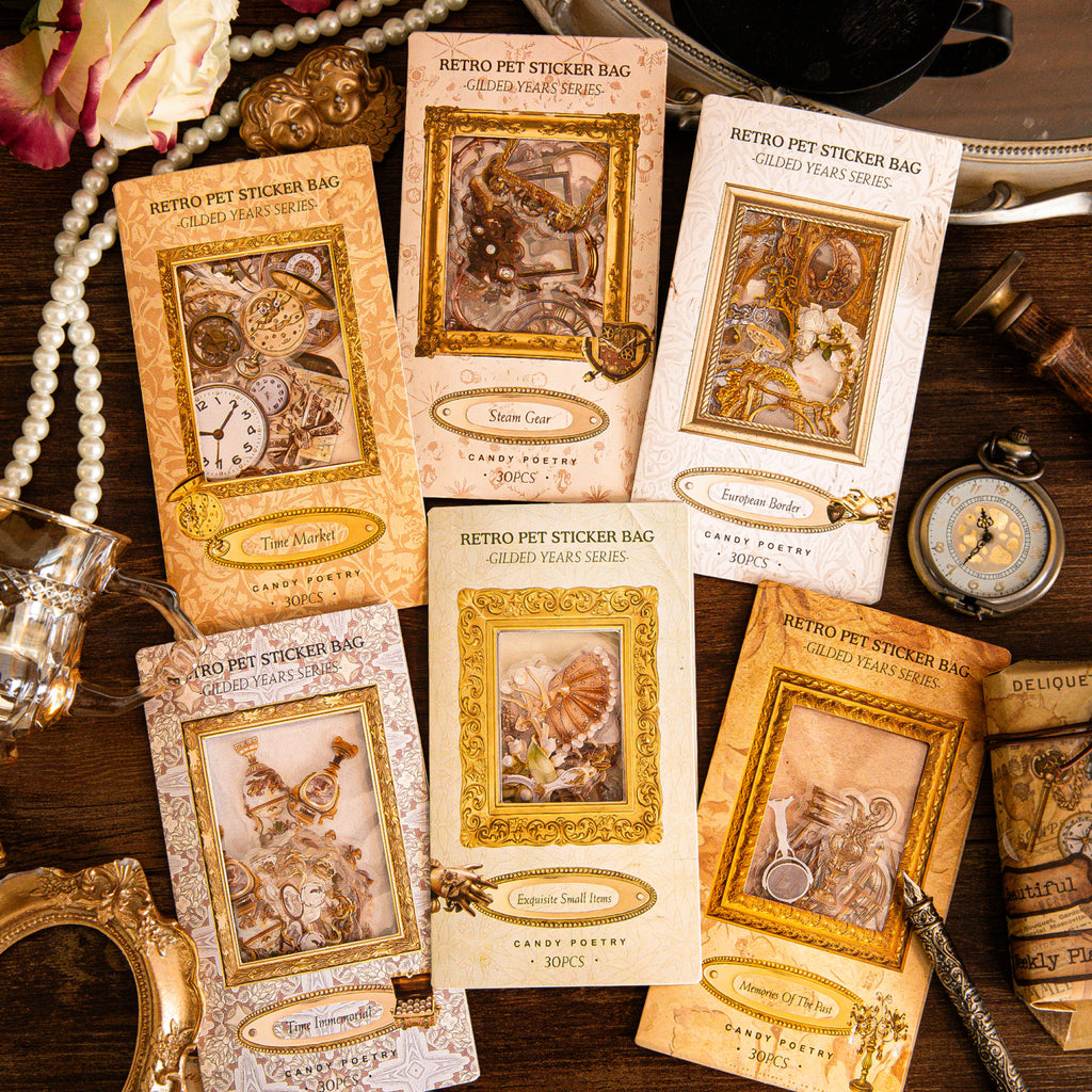 Six vintage gilded PET sticker bags arranged on a dark wooden surface with pearl strands, pocket watches, and ornate gold frames.