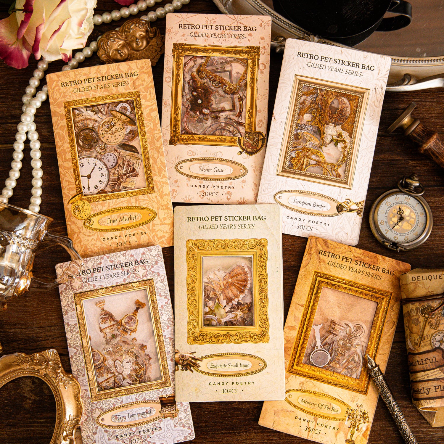 Six vintage gilded PET sticker bags arranged on a dark wooden surface with pearl strands, pocket watches, and ornate gold frames.