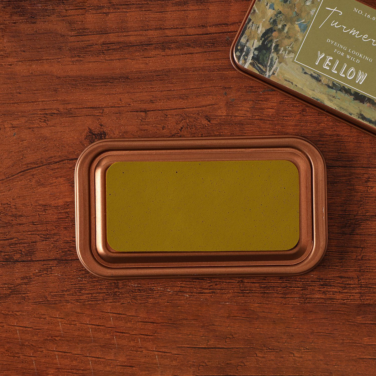 Vintage iron box ink pad in Ginger open on wood, golden grass lid beside