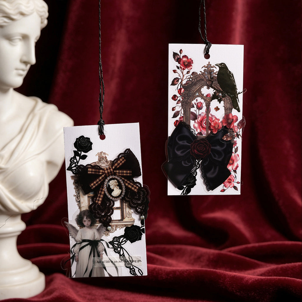 Gothic bow sticker cards arranged on red velvet with classical bust