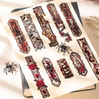 Gothic lace stickers arranged in an open journal with spider decorations