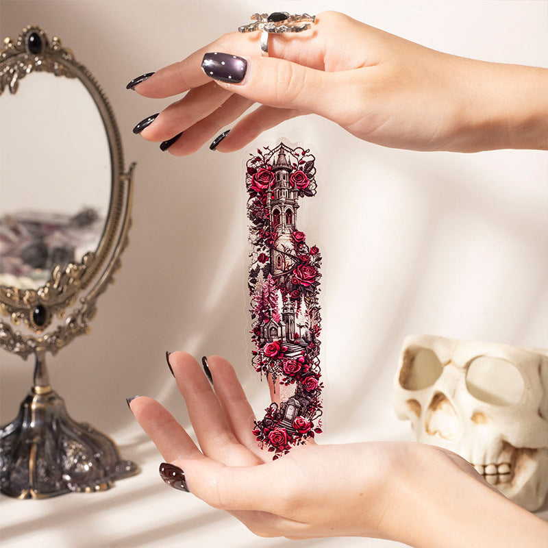 Hand holding gothic lace sticker strips in front of a vintage mirror