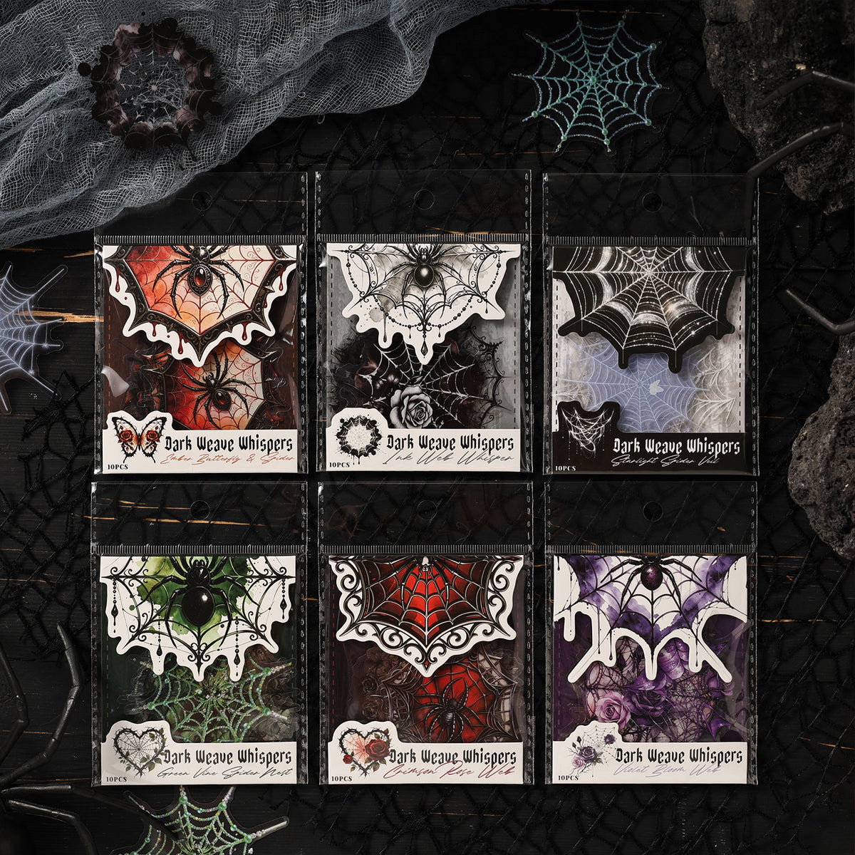 Gothic spider web sticker packs in six dark styles arranged on black web fabric