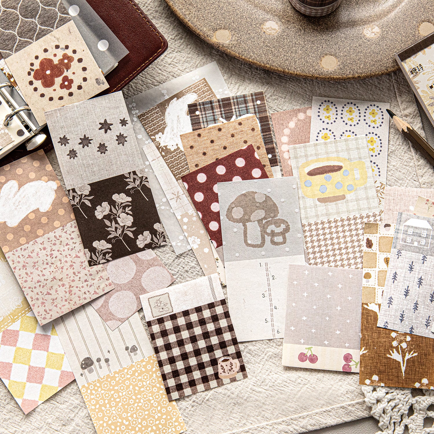 Scattered vintage green and brown ephemera paper sheets with plant illustrations and typography prints, mixed lightweight paper and PET overlays for scrapbook decoration